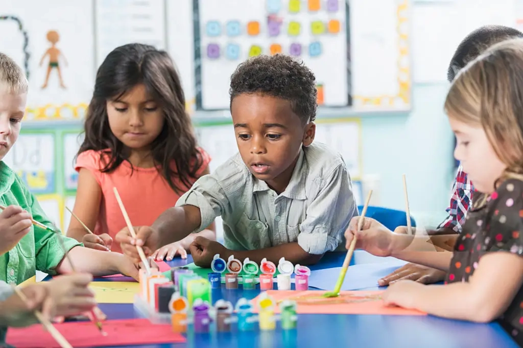 Children painting together at a classroom table
