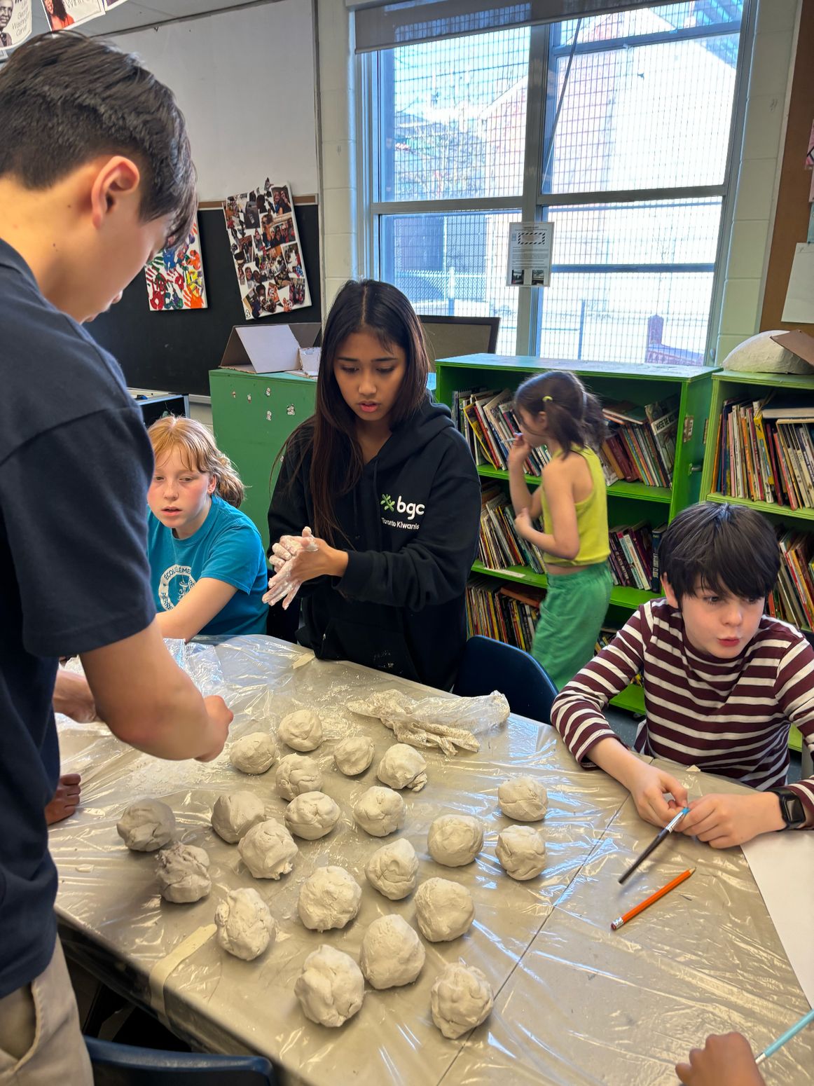 Children and volunteers preparing clay at a workshop