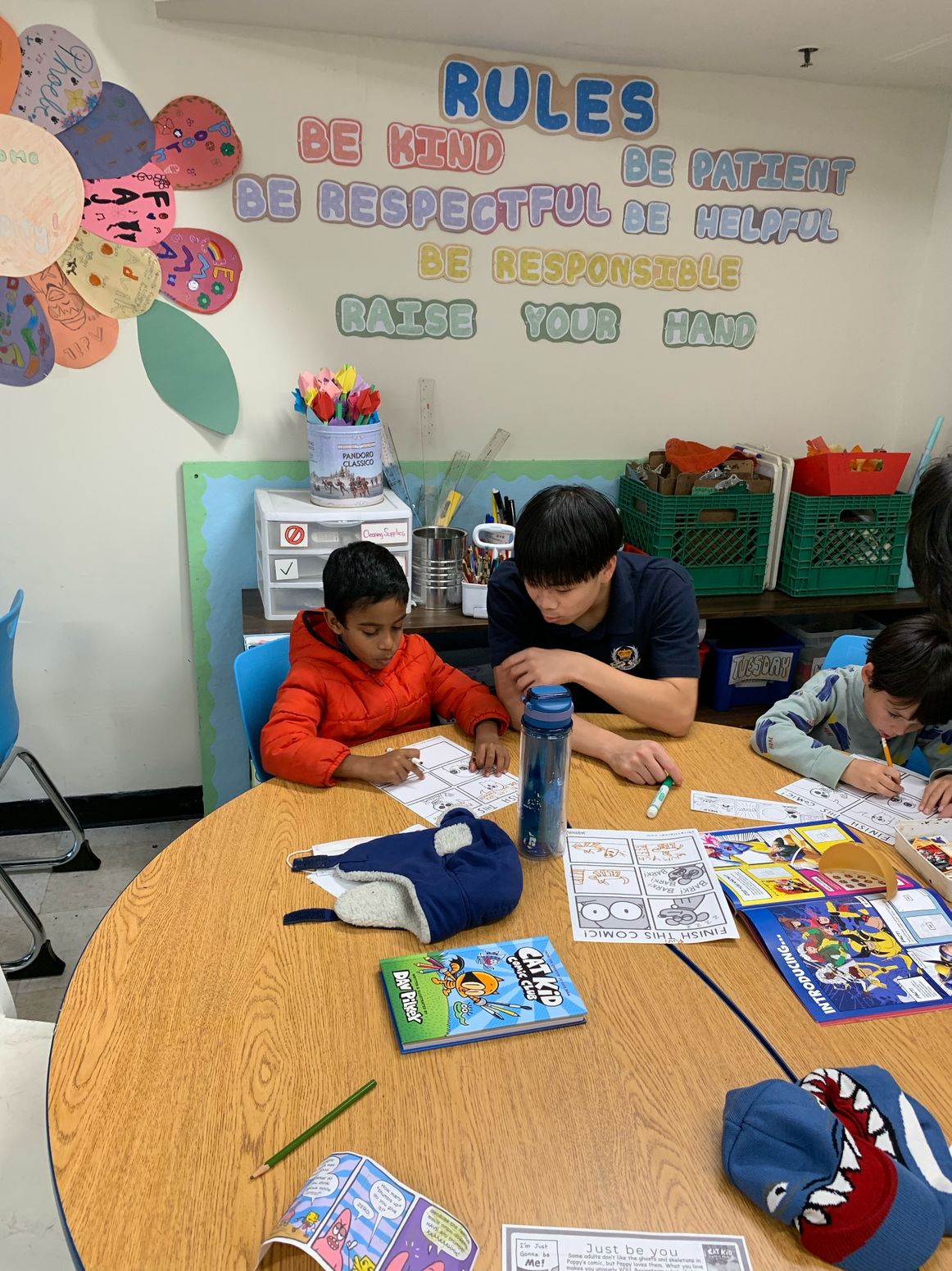 Volunteer supporting a child during a drawing activity