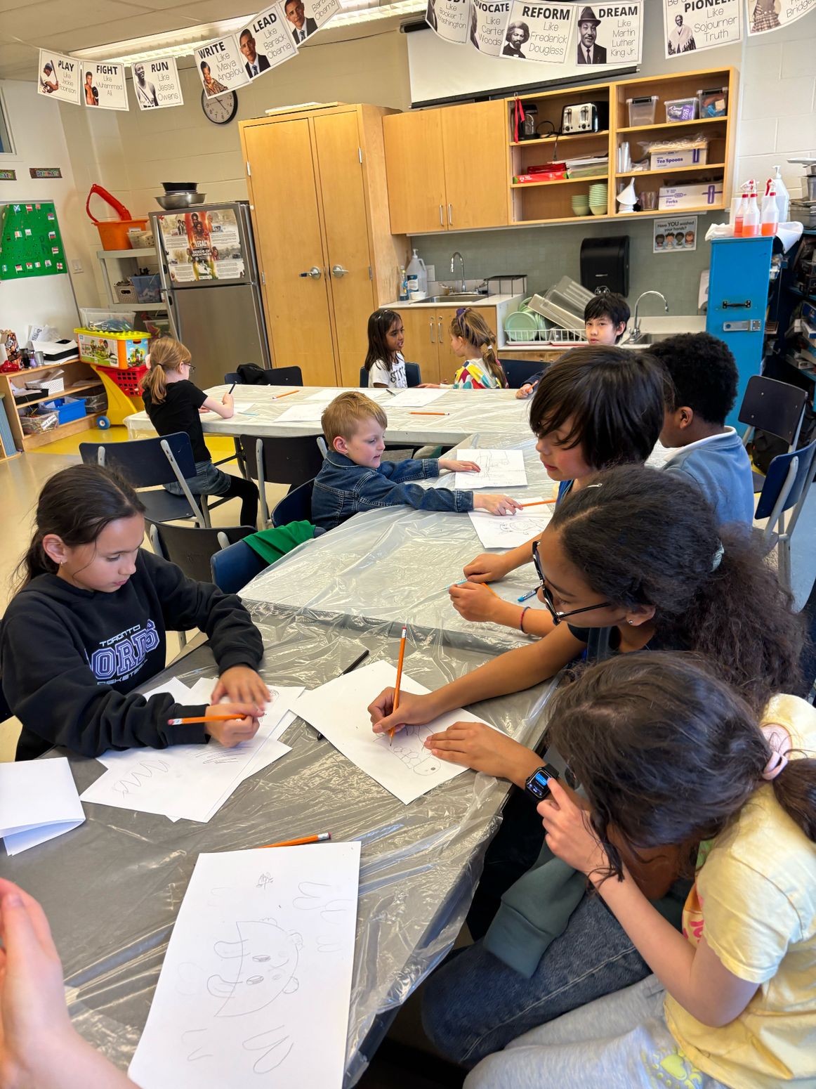 Young artists drawing together during a Hands & Canvas workshop