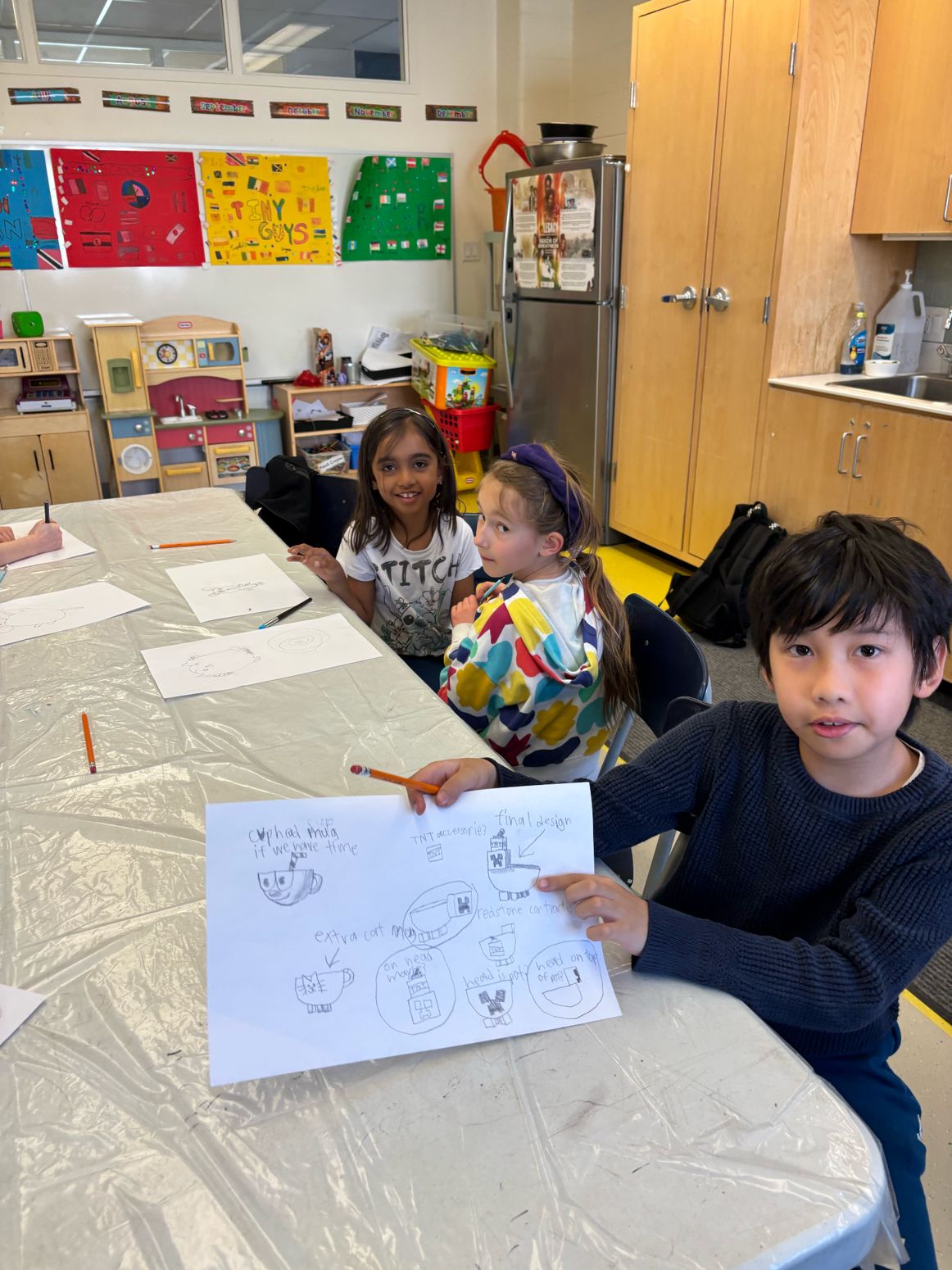 Child showing a drawing concept at the workshop table